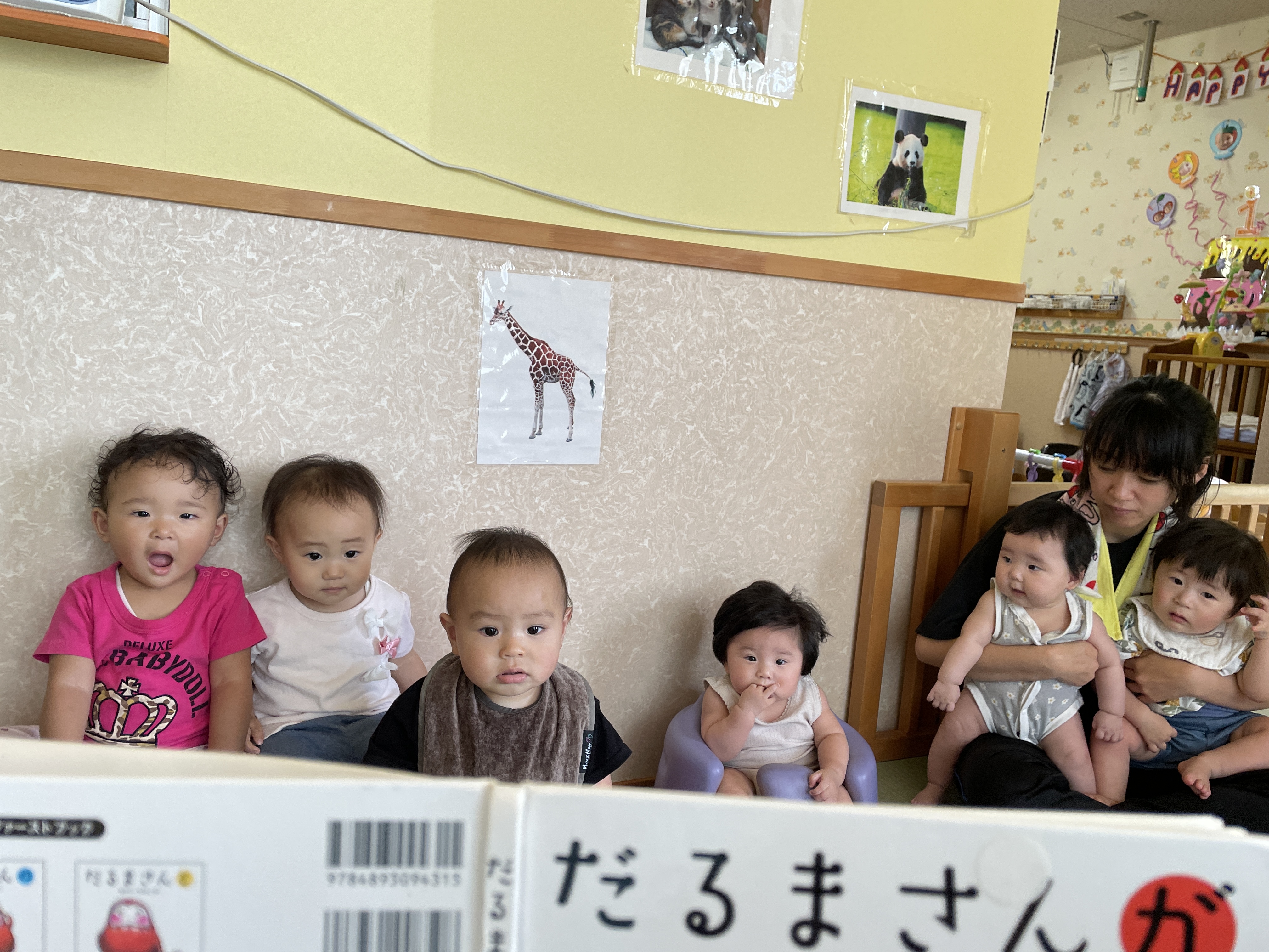 絵本の読み聞かせ。「お話しお話しパチパチ♪」と歌が始まるとじーっと先生の顔を見ます。絵本好きになってくれますように…。